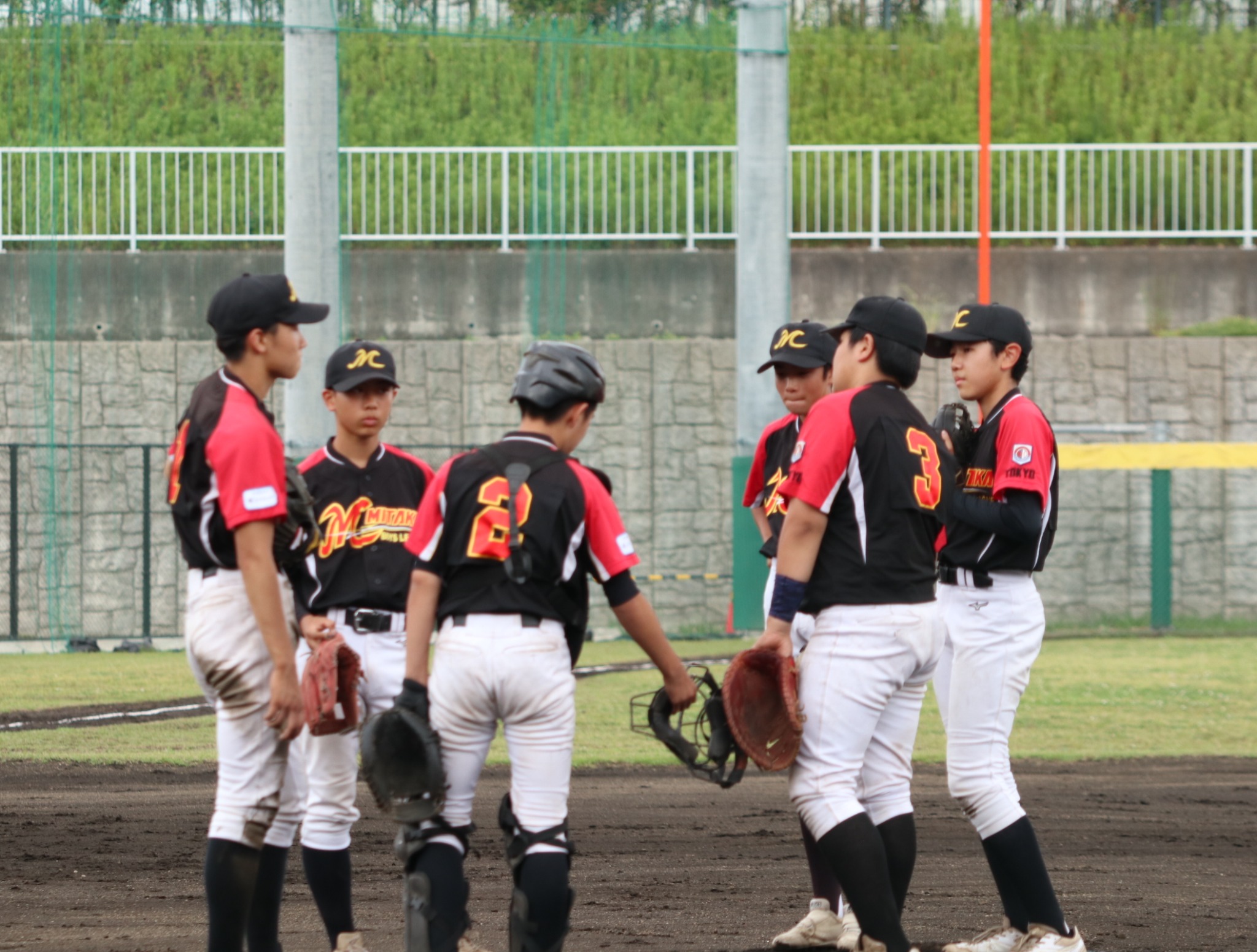 グラウンドで集まり、話し合う選手たち